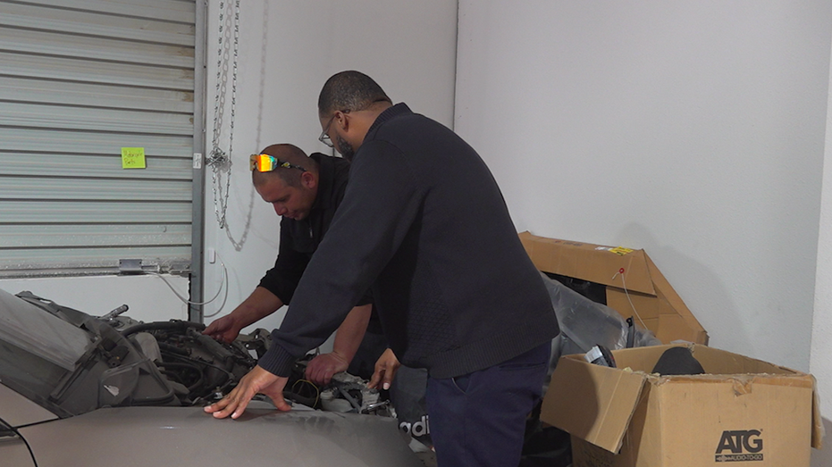 Two men examining a car